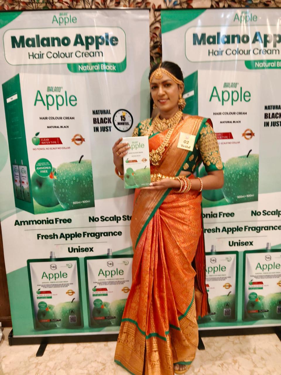 Exhibition participant presenting Malano Apple hair colour cream packaging at trade fair booth