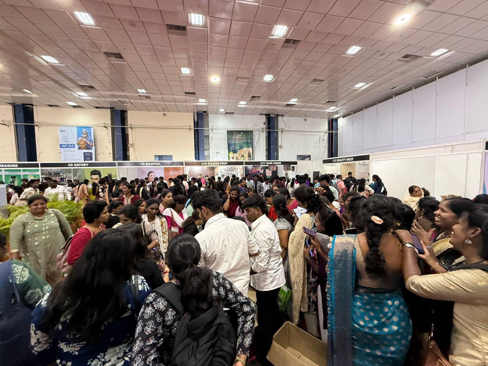 Crowd engagement view from trade fair floor showing visitor traffic around exhibition stands