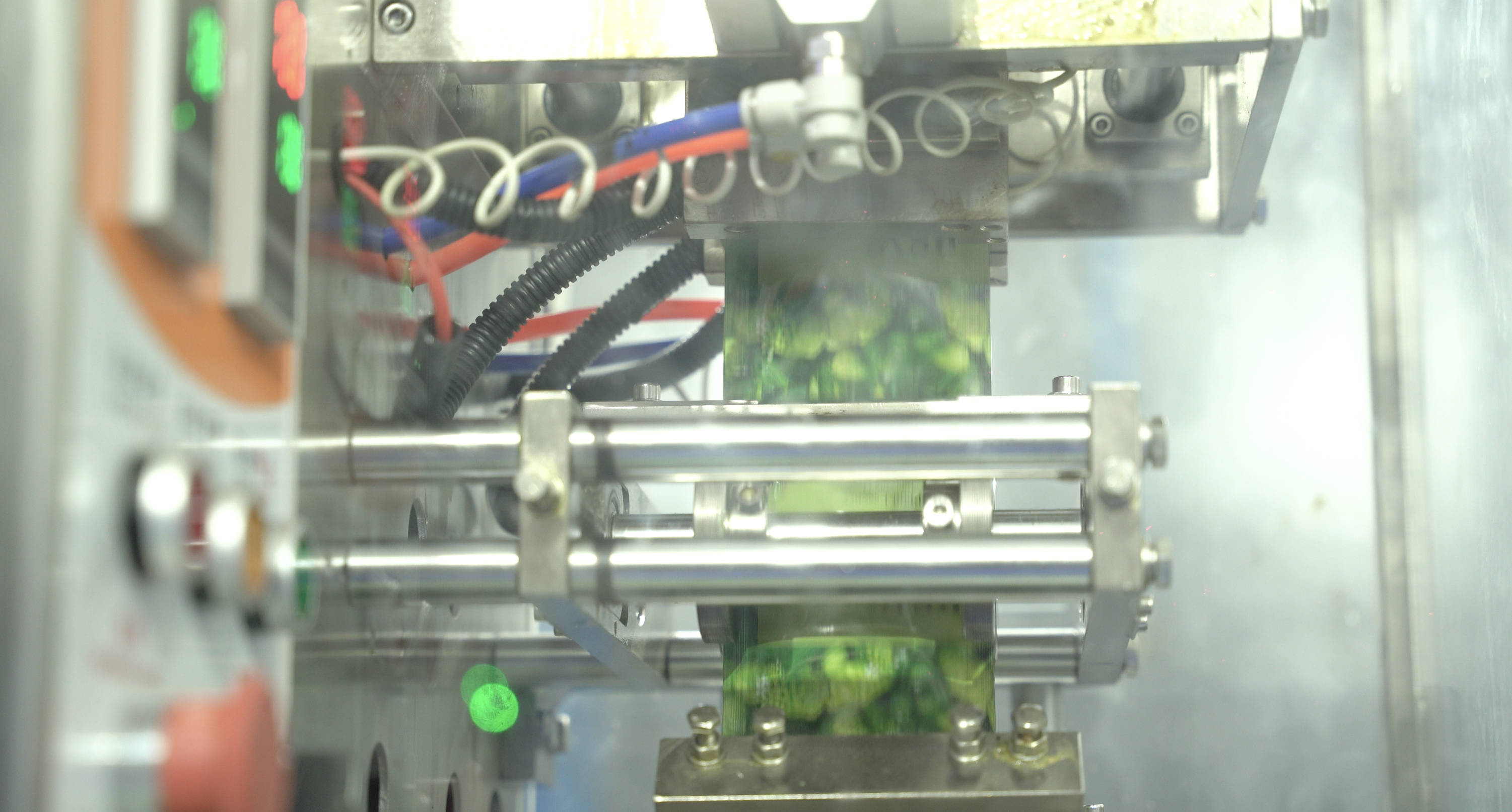 Sachet filling machine close-up showing hopper, pump system, and filling components